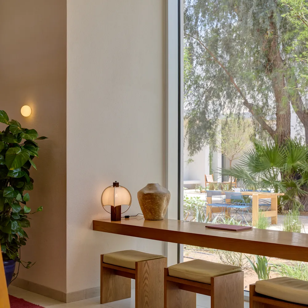A window bench and low table in a light filled corner of Paus