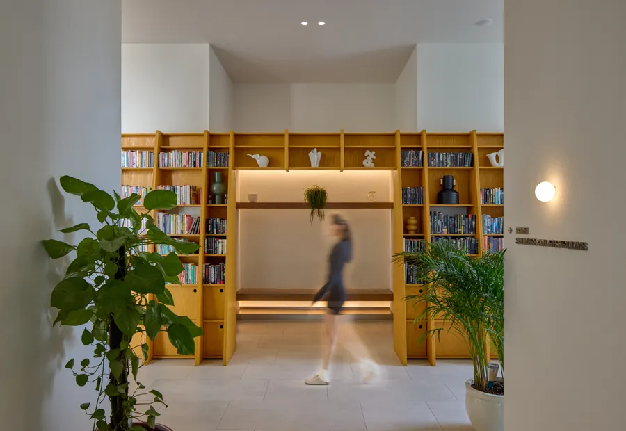 The yellow library wall at Paus with a member passing through